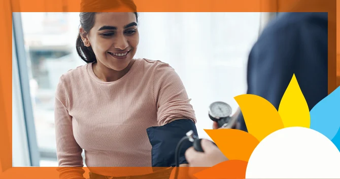 a smiling person has their bloodpressure checked